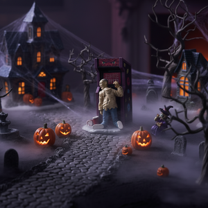 Halloween-themed diorama with pumpkins, a haunted house, and a figure in front of an arcade machine.